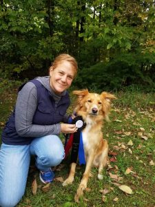 Dog trainer Katie with dog and dog training award